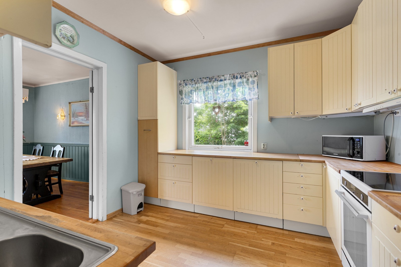 Profilert kjøkkeninnredning med over- og underskap samt høyskap Galleribilde