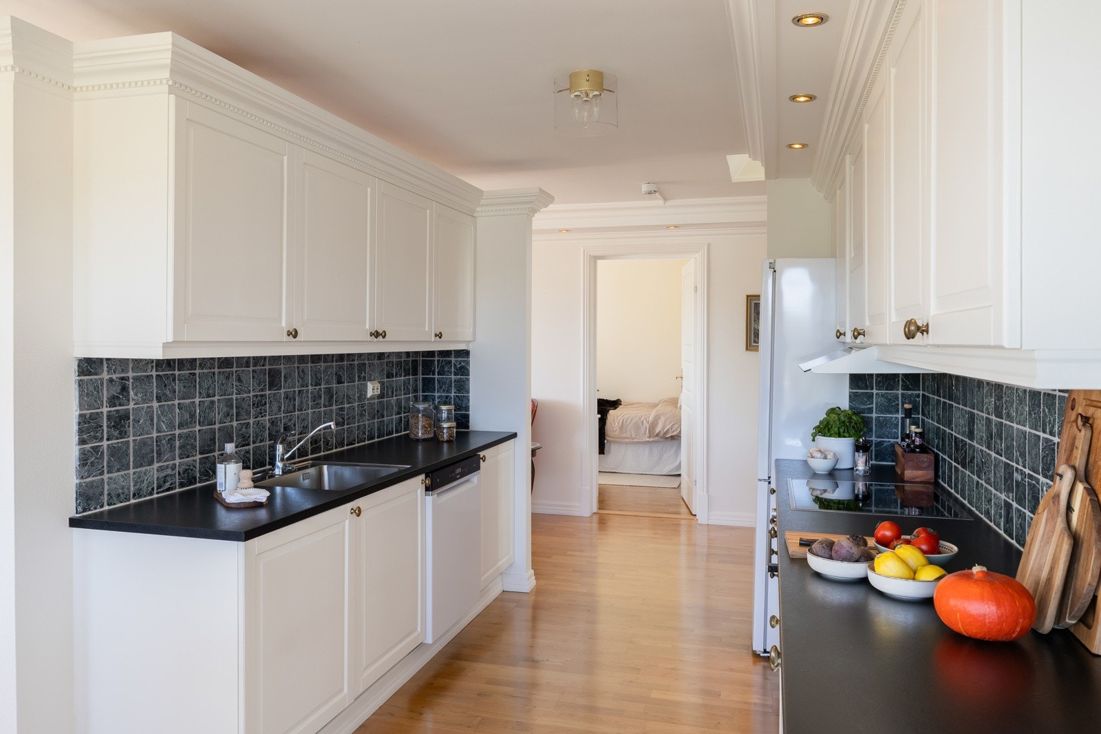 Det er lagt vekt på funksjonelle løsninger og gode oppbevaringsmuligheter, og med overskap er det rikelig med skapplass. Velutstyrt med integrerte hvitevarer som oppvaskmaskin, platetopp og stekeovn. Galleribilde