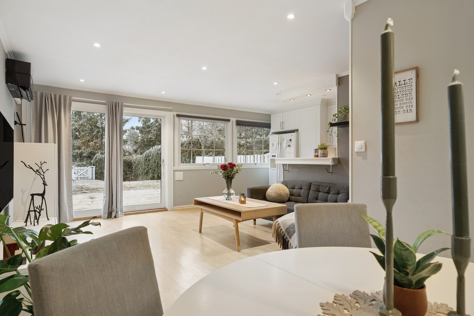 Stue med åpen kjøkkenløsning, lyse vegger og store vindusflater som gir godt med naturlig lys. Galleribilde