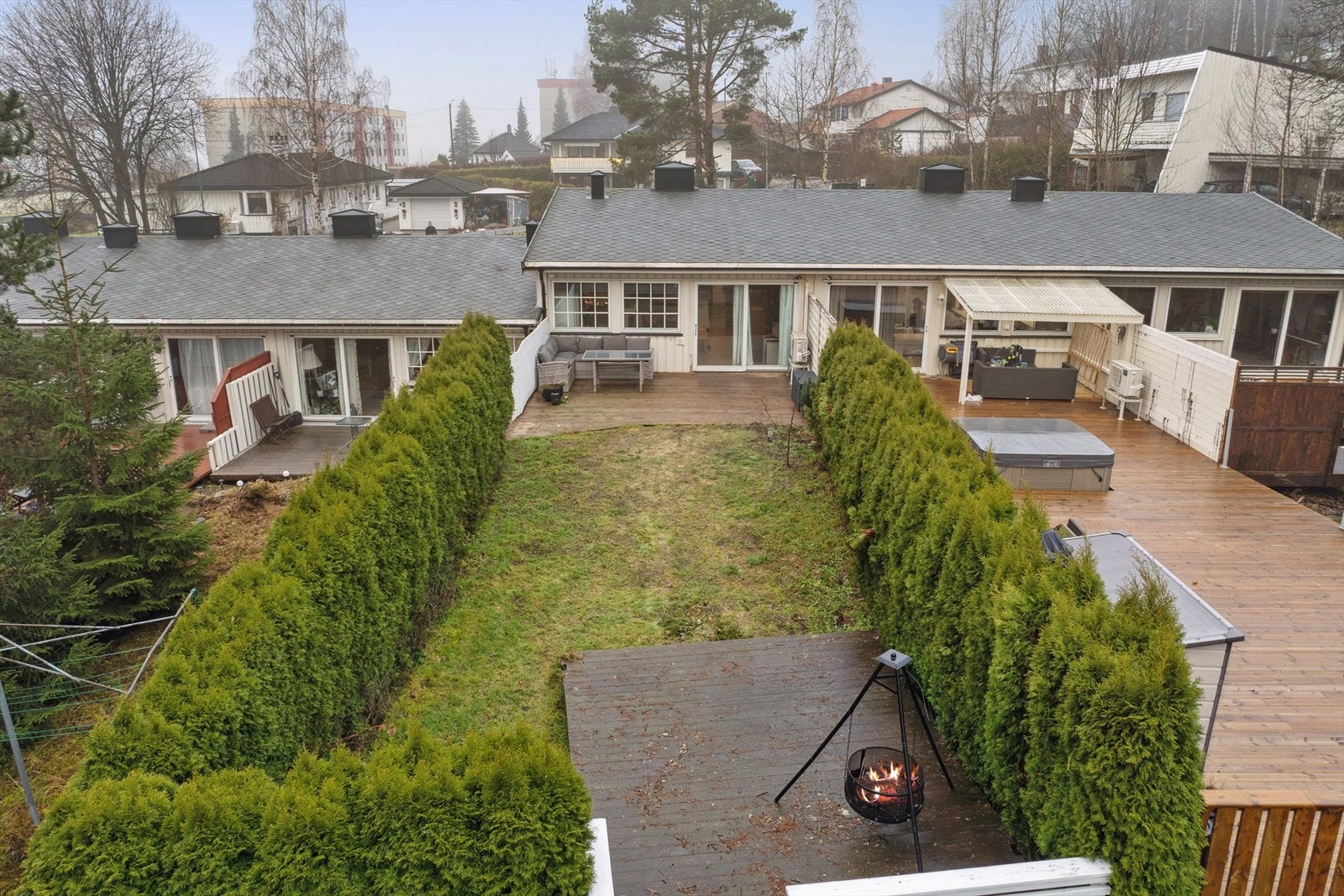 Rekkehusets tomt er opparbeidet med gressplen og treplattinger som gir gode uteplasser for både lek, avslapning hyggelige grillkvelder. Galleribilde