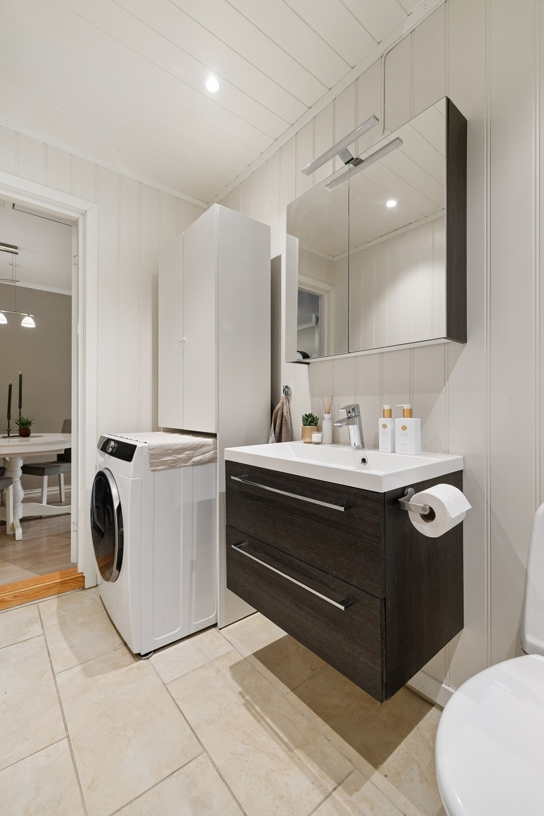 Baderommet har opplegg for vaskemaskin, samt skap med hyller som gir praktisk oppbevaring. Galleribilde