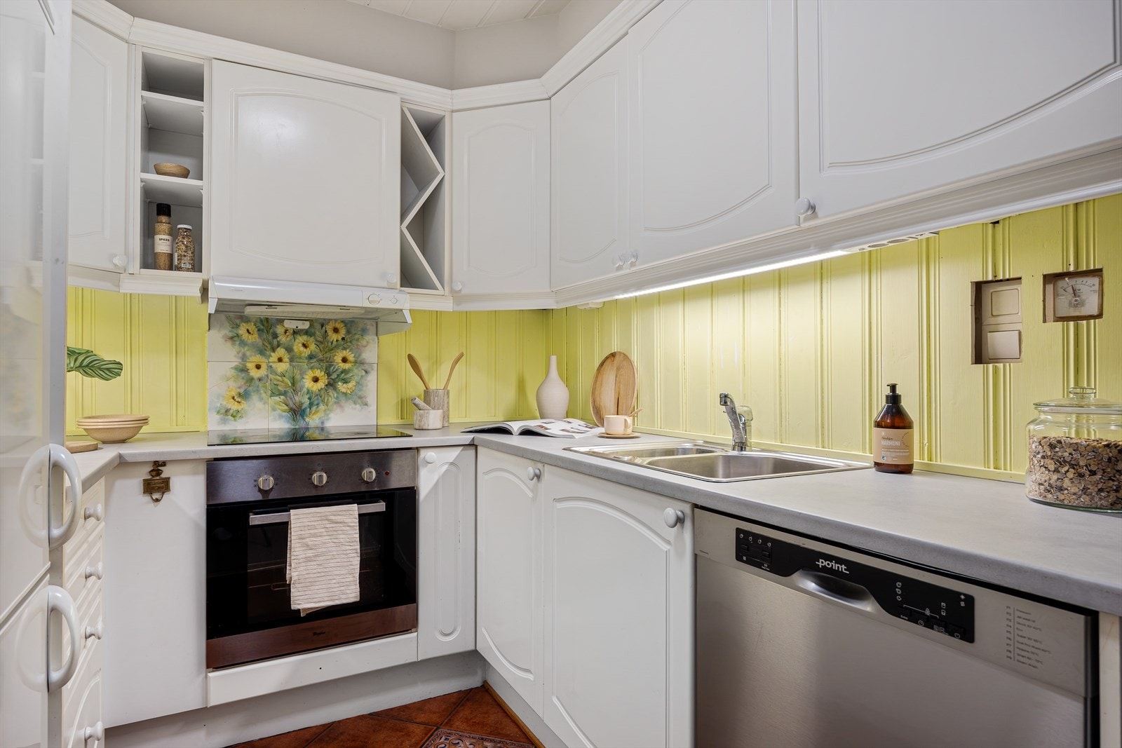 Kjøkkeninnredning med hvite, profilerte fronter og laminert benkeplate med dobbel kjøkkenvask i stål Galleribilde