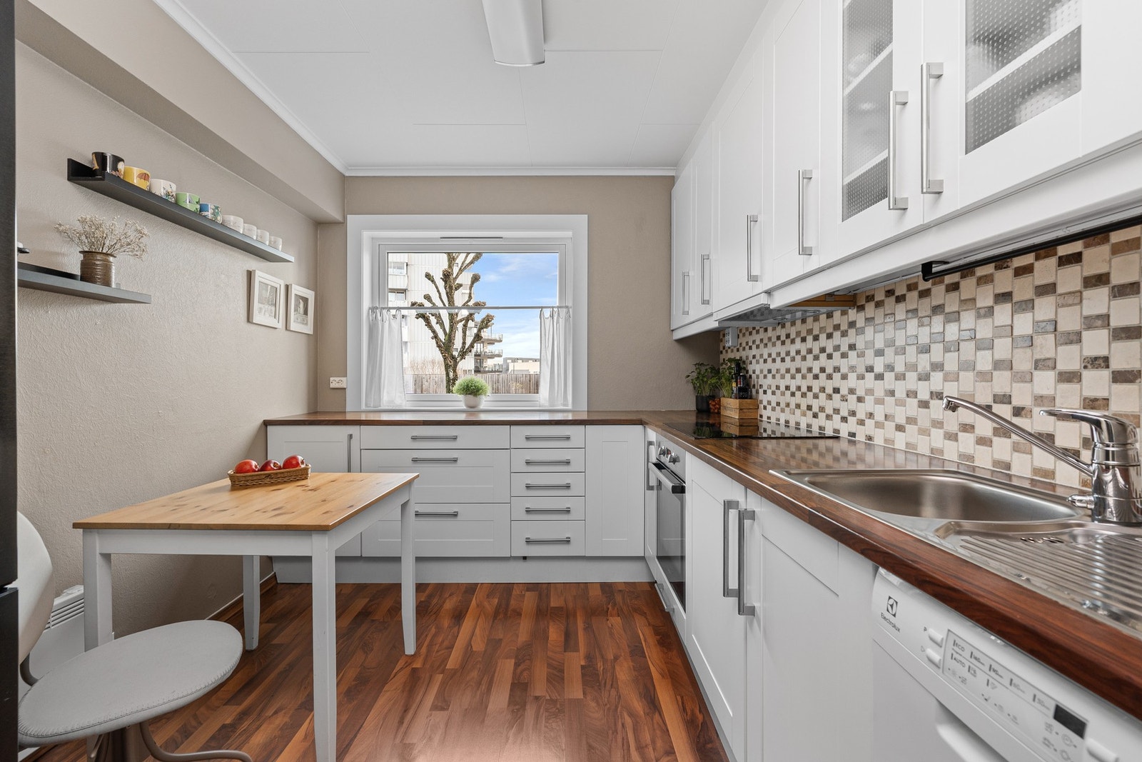 Kjøkkenet er utformet i en heldig L-form og sørger for god arbeidsflyt og rikelig med skap - og benkeplass. Galleribilde