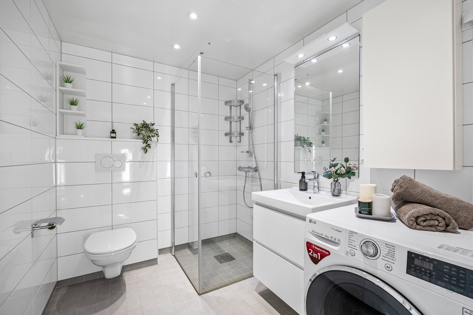 Lekkert baderom av god størrelse med både gulvvarme, downlights og opplegg for vaskemaskin og tørketrommel Galleribilde