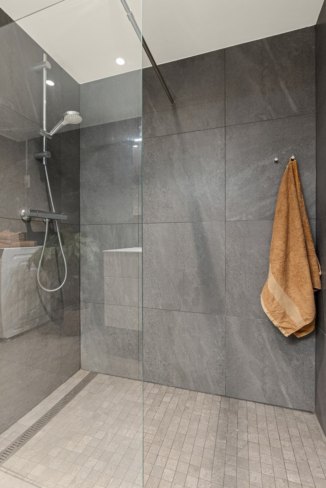 Badet fremstår delikat med moderne detaljer og stilfulle fliser som gir et eksklusivt preg. Galleribilde