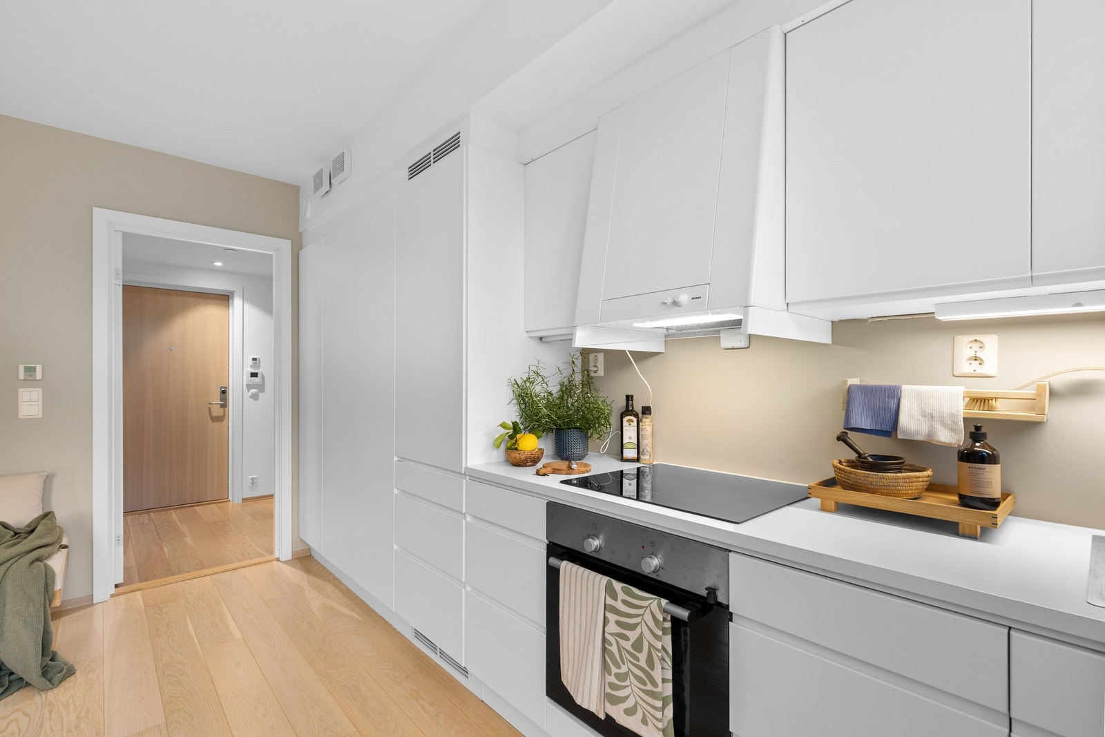 Kjøkkenet er godt utnyttet med mye skapplass. De to skapdørene mot gangen er klesskap, med samme fronter som resten av kjøkkenet Galleribilde