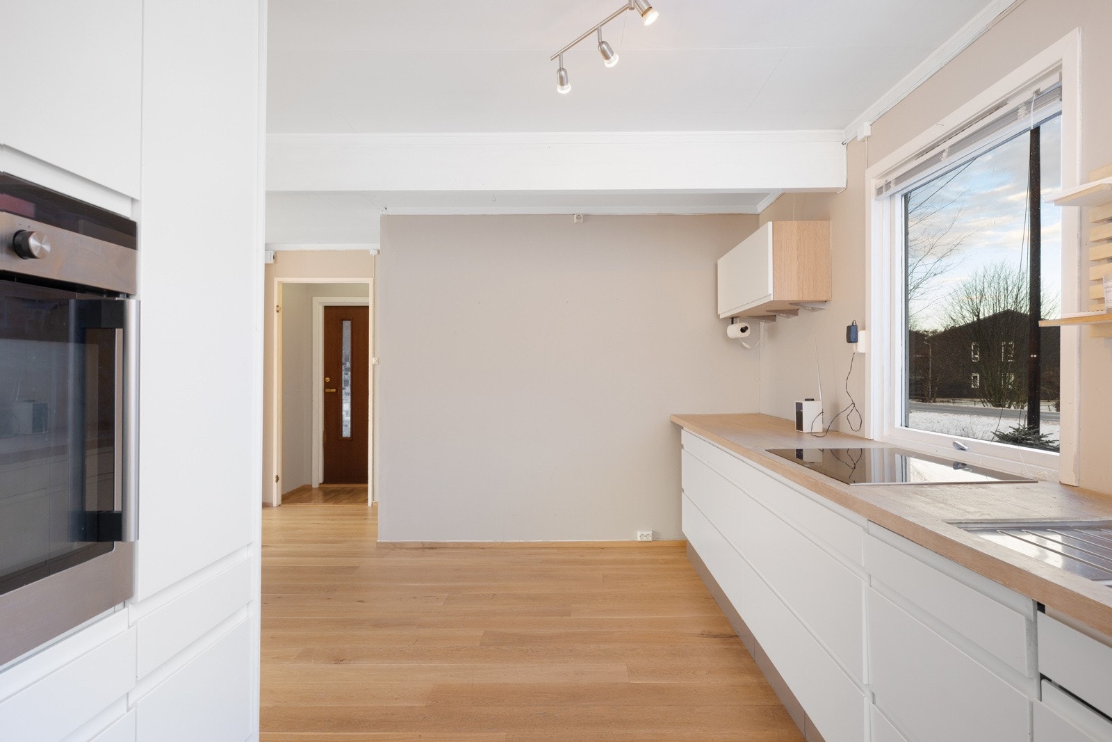 Lys og moderne kjøkken med god benkeplass og integrerte hvitevarer. Galleribilde