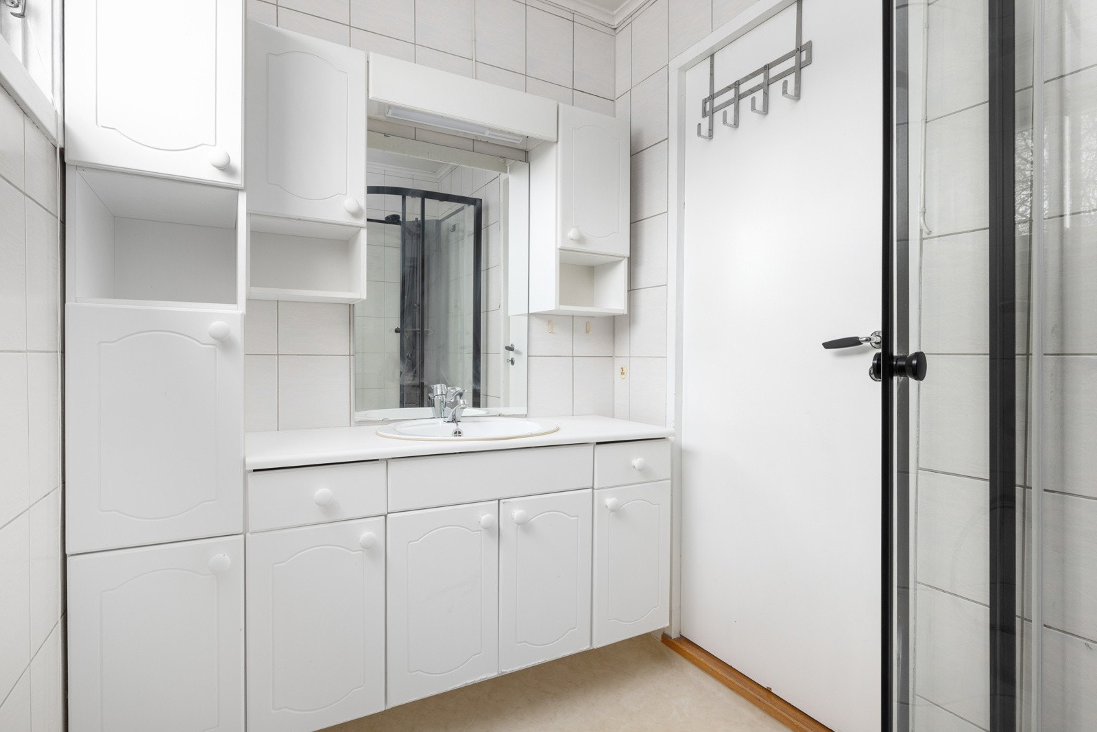 Praktisk og lyst baderom med god skapplass, speilskap og dusj med glassvegger. Galleribilde