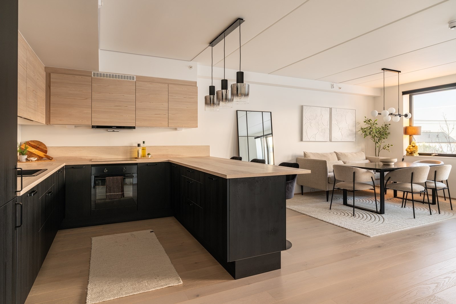 Den åpne løsningen mellom stue og kjøkken skaper en sosial og luftig sone. Galleribilde