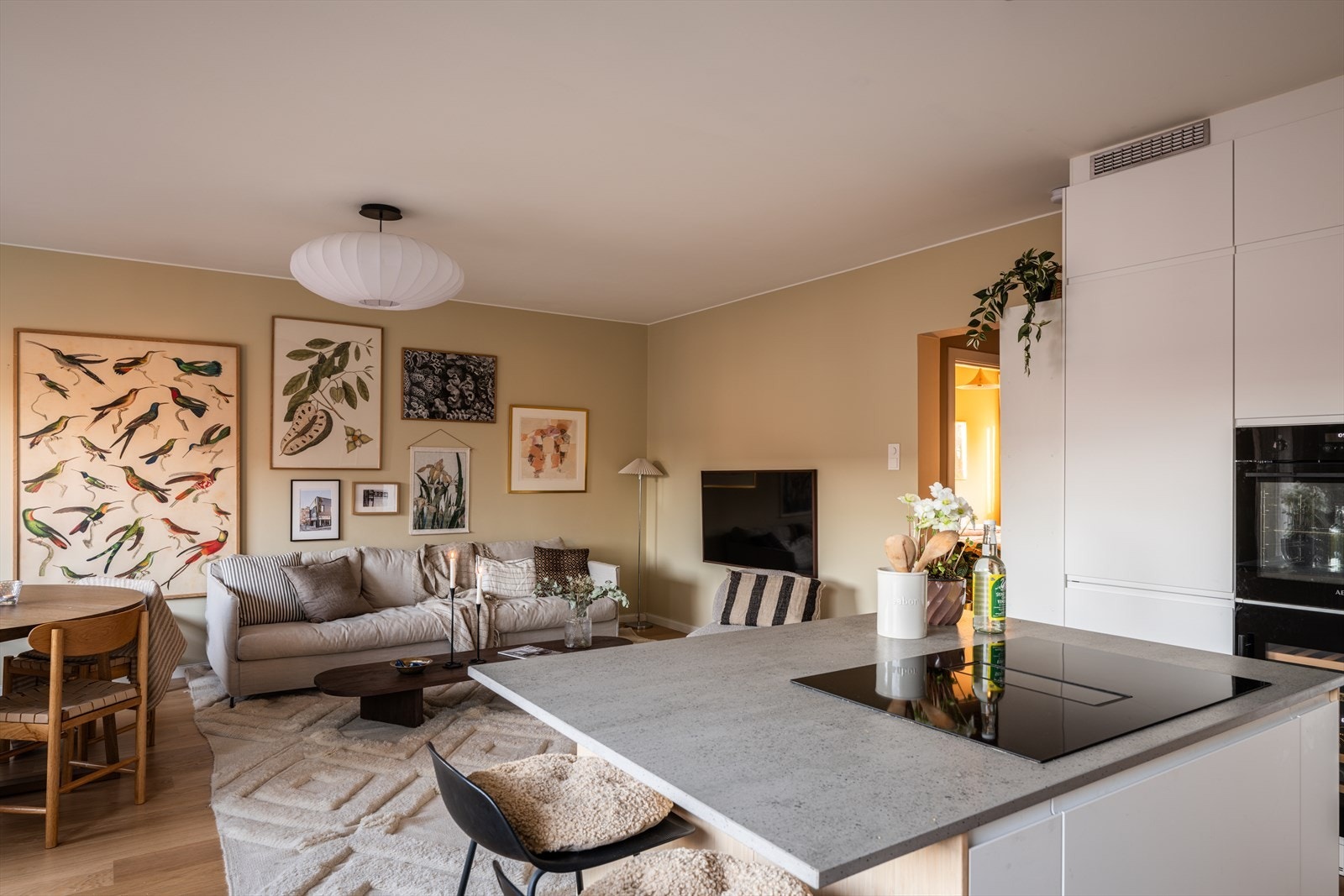 Åpen løsning mellom stue og kjøkken skaper en luftig og sosial atmosfære. Galleribilde