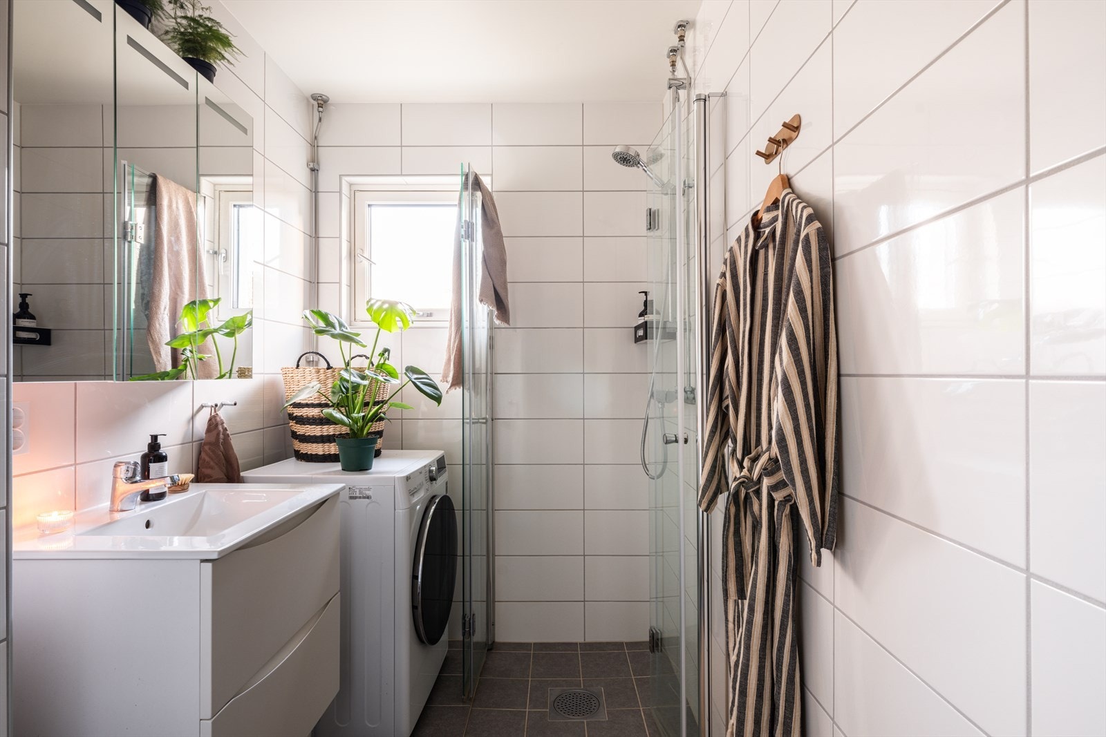 Badet er utstyrt med dusjhjørne med innfellbare dører og opplegg for vaskemaskin. Galleribilde