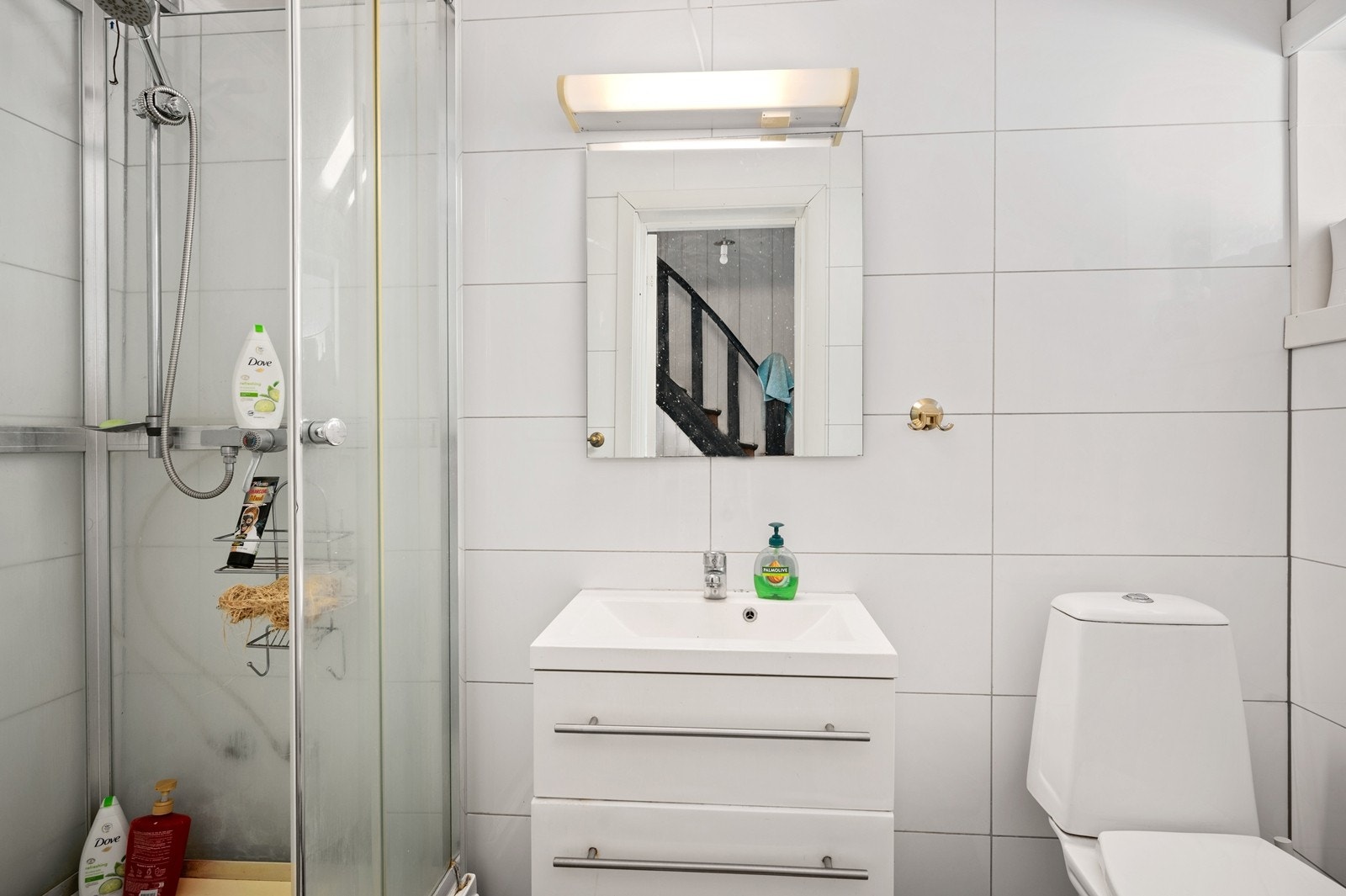 Bad 2 i første etasje har gulvstående toalett, vegghengt servantskap med skuffer og dusjkabinett med tilkoblet hånddusj. Galleribilde