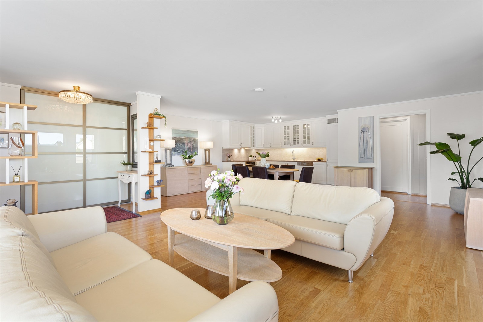 Åpen kjøkken- og stueløsning med sofaområde samt spiseplass Galleribilde