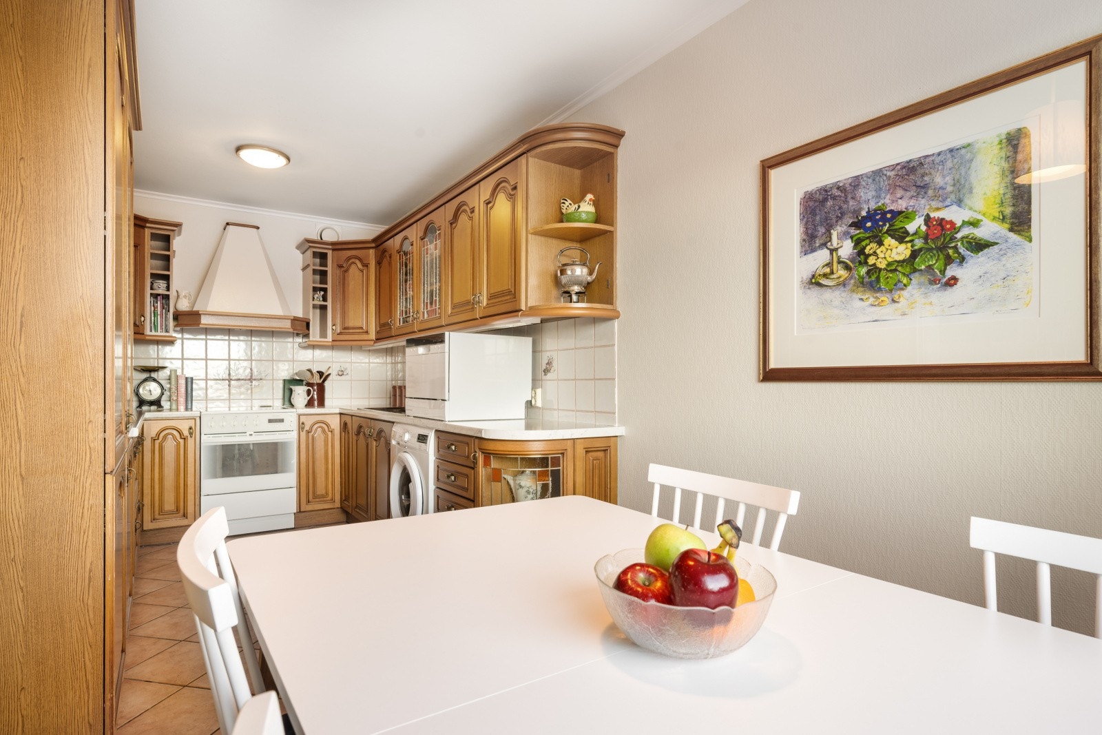 Kjøkkenet har en tidløs innredning med profilerte fronter og benkeplate i laminat med nedfelt oppvaskkum i stål Galleribilde