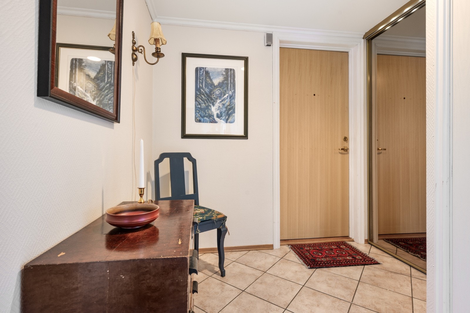 Du ønskes velkommen inn i en hyggelig flislagt entrè utstyrt med skyvedørsgarderobe Galleribilde