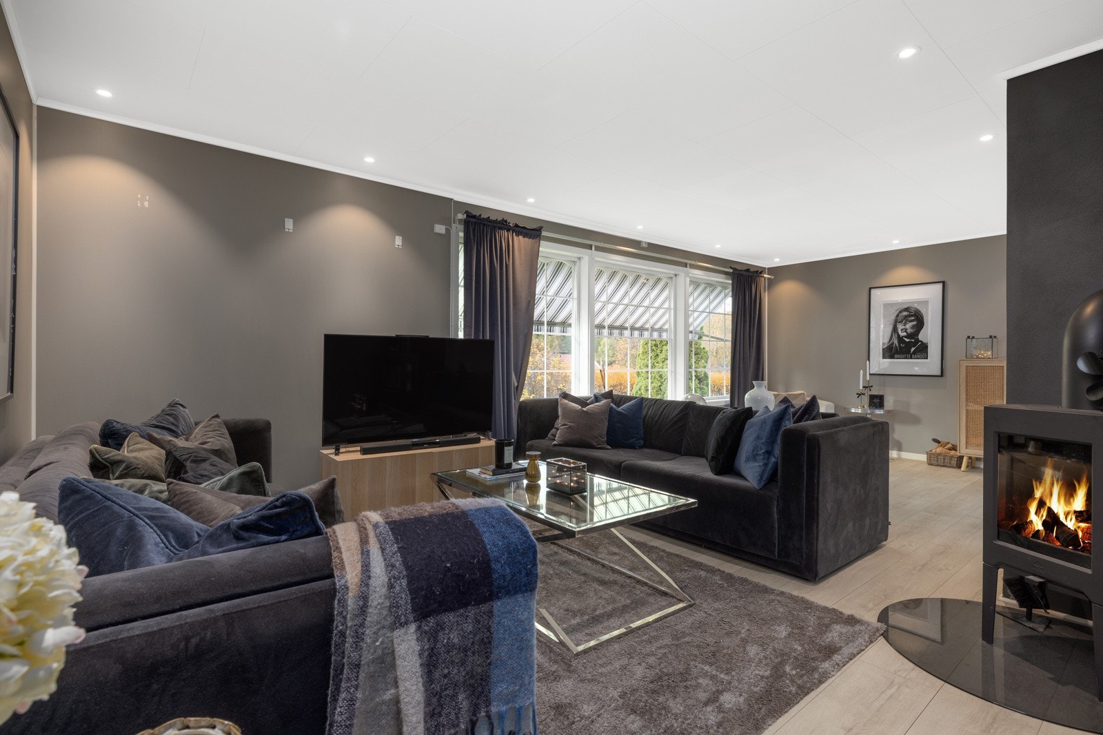 Romslig og stilfull stue med store vindusflater, peisovn og god plass til både sofagruppe og spiseplass Galleribilde