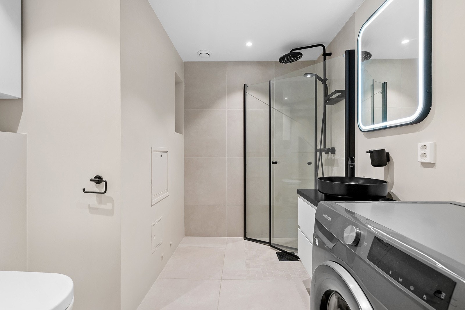 Romslig bad med varmekabler og downlights nyoppusset i 2023. Opplegg for vaskemaskin Galleribilde