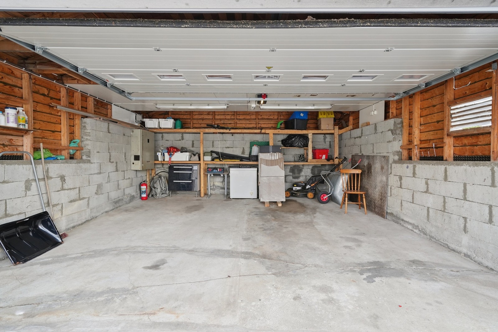 Parkeringen kan gjøres i den store garasjen - denne fikk ny taktekking i 2017 og porten ble byttet i 2024. Galleribilde