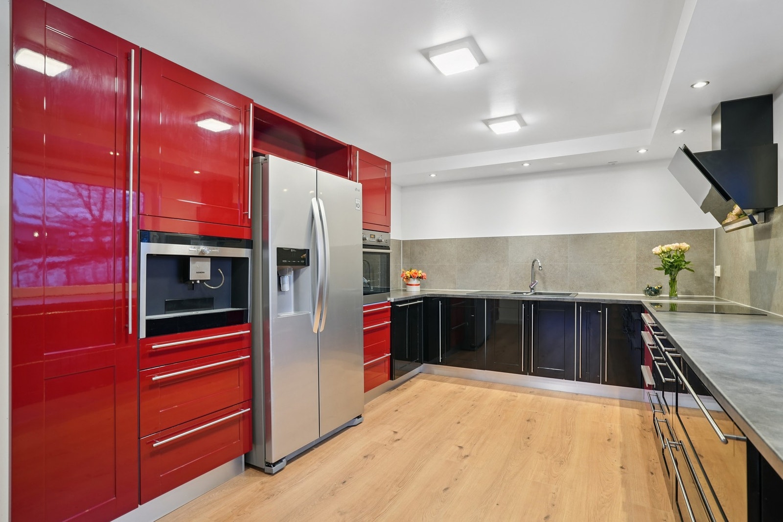 Kjøkkeninnredningen har glatte høyglans fronter i sort og rød utførelse, samt en laminat benkeplate med nedfelt oppvaskkum. Galleribilde