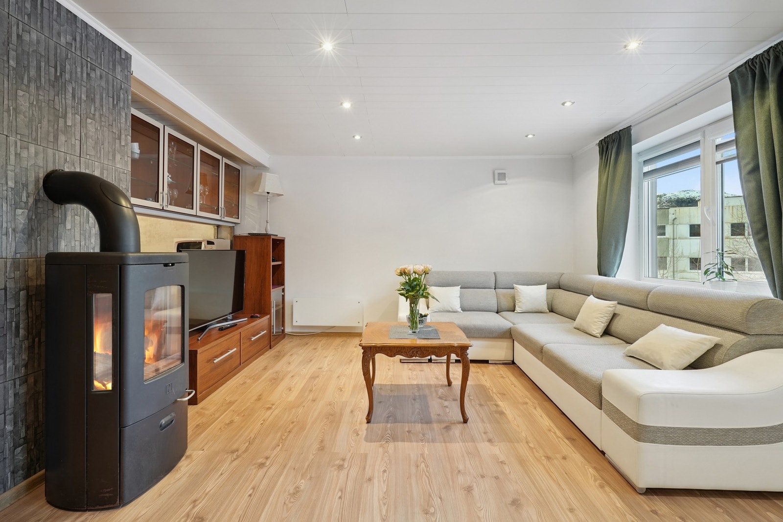 Midt i rommet er det ildsted som sørger for god varme nå på vinterstid. Galleribilde