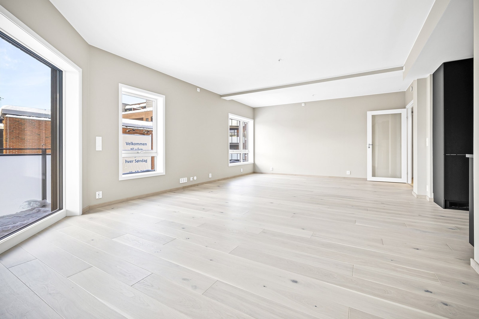 Romslig åpen kjøkken- og stueløsning med store vindusflater Galleribilde