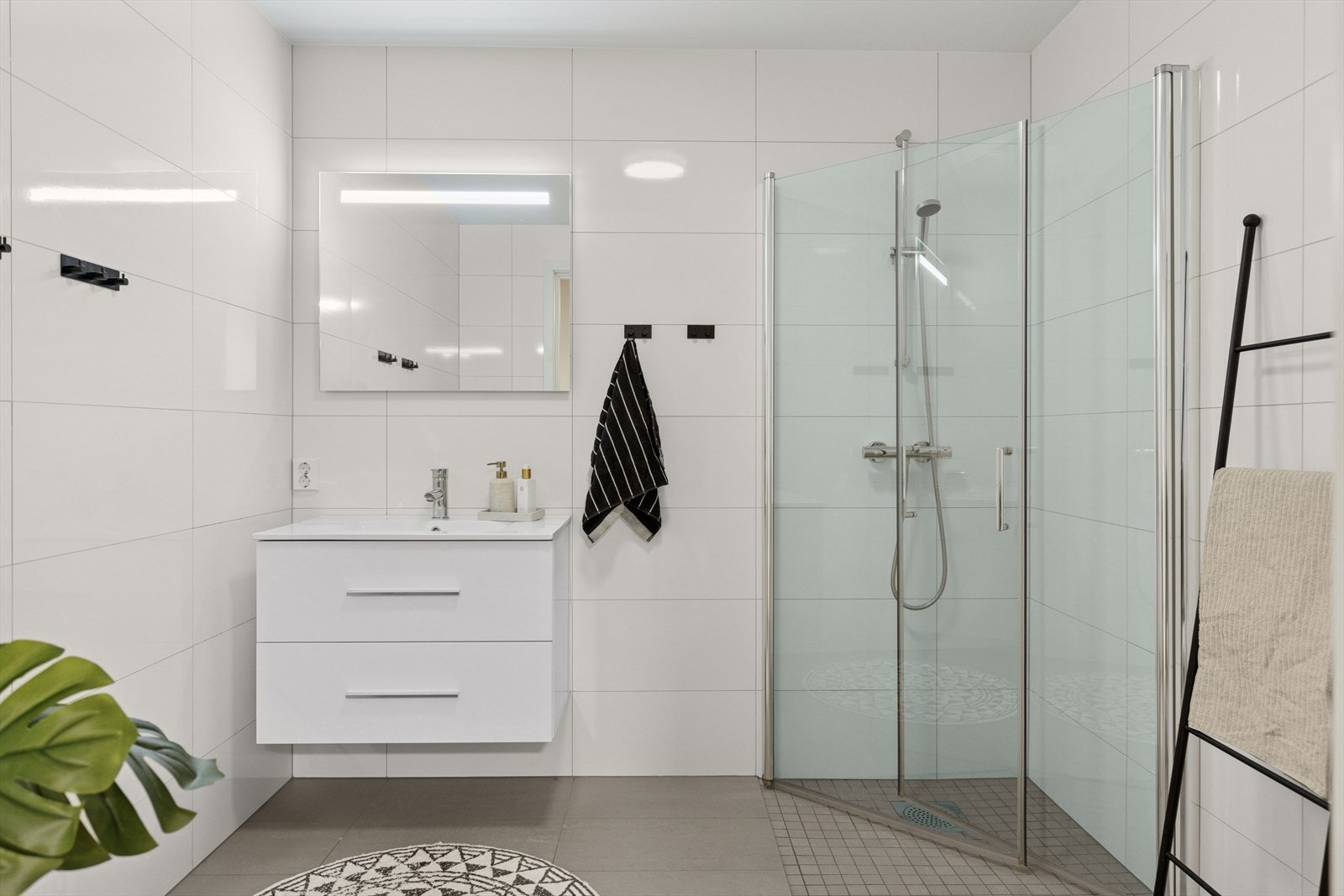 Tidsriktig og delikat bad, med baderomsmøbler, vegghengt toalett og plassbesparende dusj-dører Galleribilde