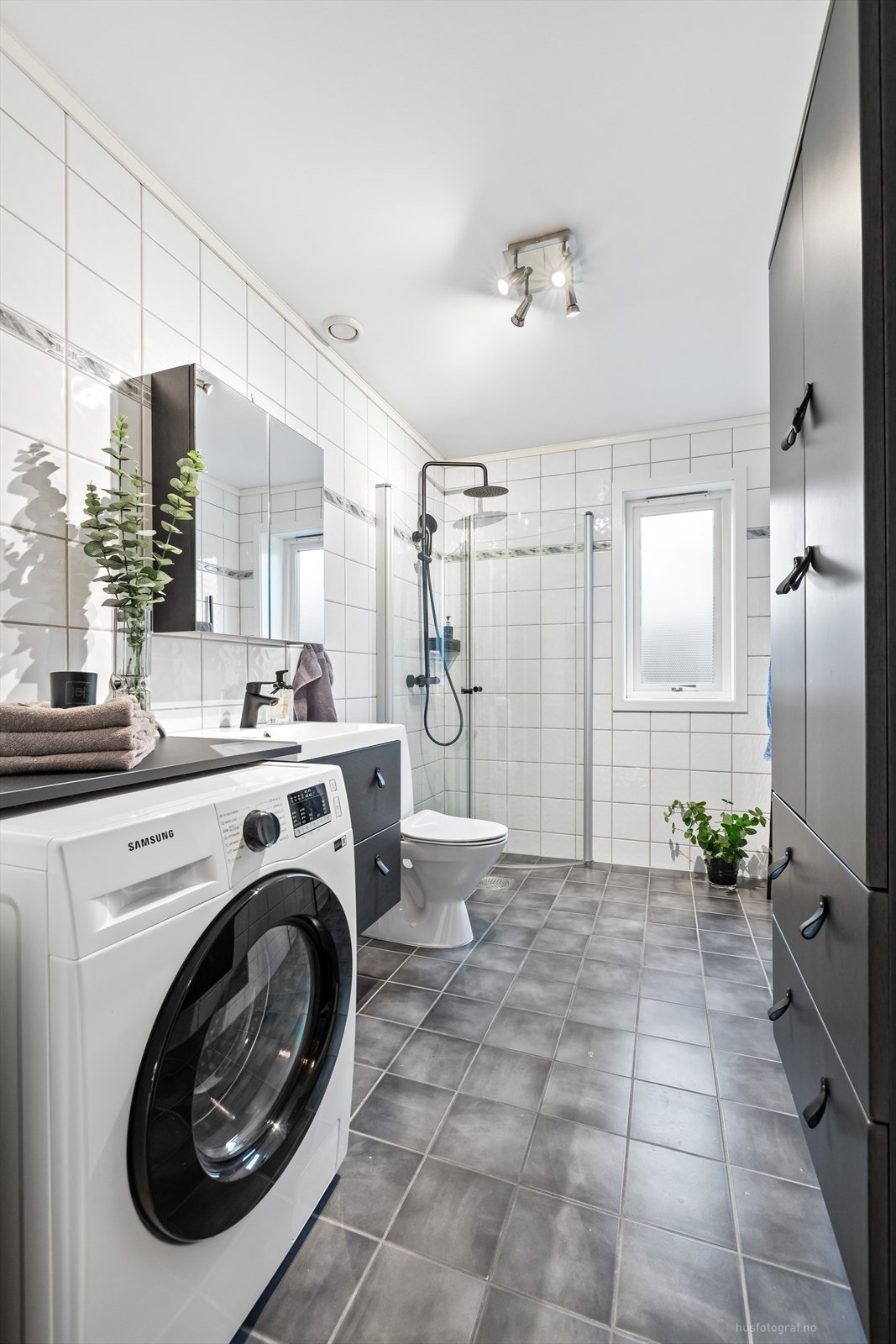 Videre er badet utstyrt med dusjhjørne med innfellbare dusjdører, toalett og det er opplegg for vaskemaskin. Galleribilde