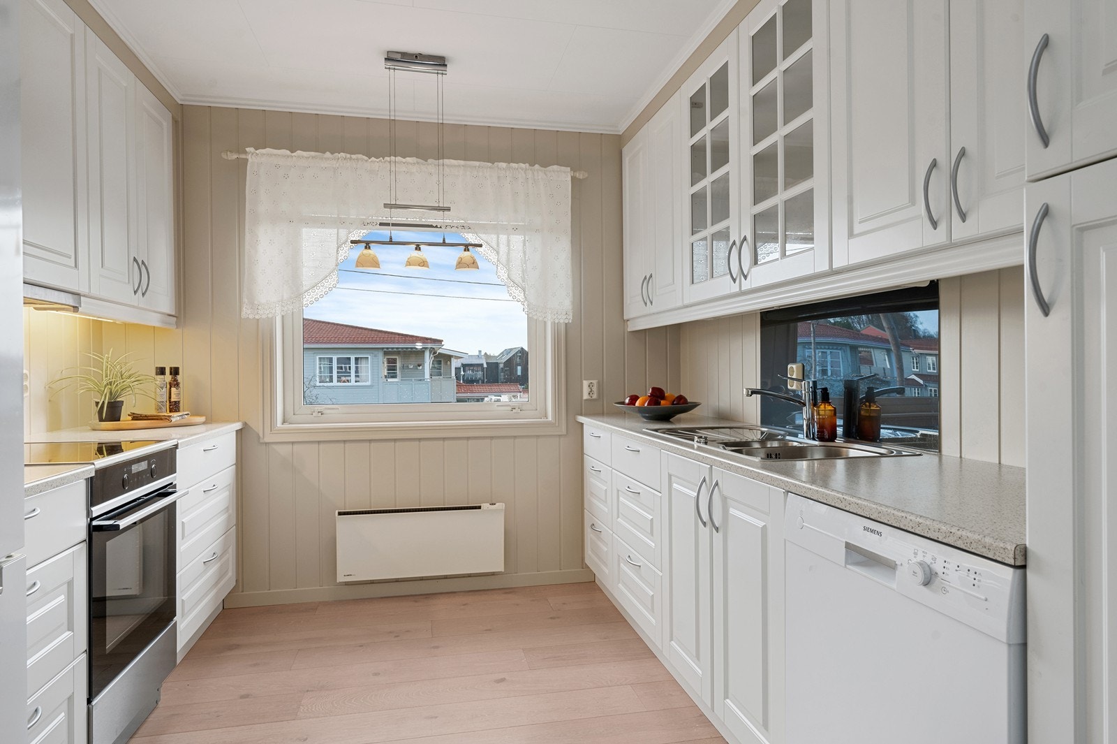 Kjøkkenet har en funksjonell innredning fra 2014 med fabrikklakkerte fronter og laminat benkeplate. Eget vindu på kjøkkenet slipper inn godt med dagslys også her. Galleribilde