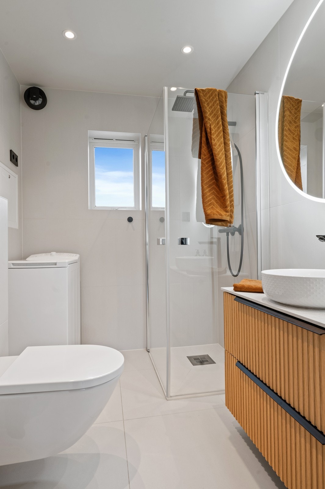 Her er det delikat helfliset, med varmekabler i gulvet. Videre er det vegghengt toalett, dusjhjørne med glassdører og opplegg for vaskemaskin Galleribilde