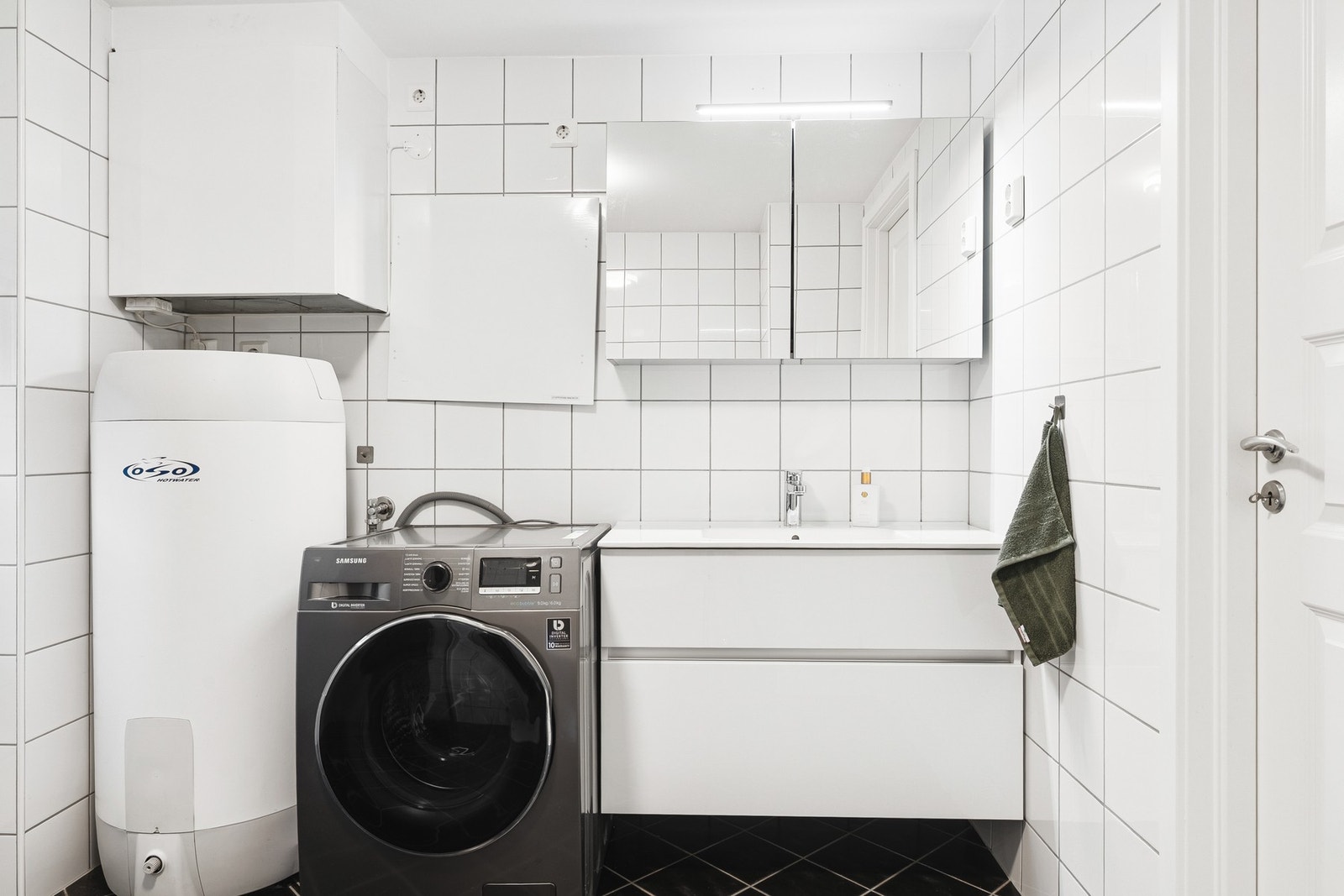 Badet er innredet med servant med underskap, toalett, dusjhjørne og opplegg for vaskemaskin. Galleribilde