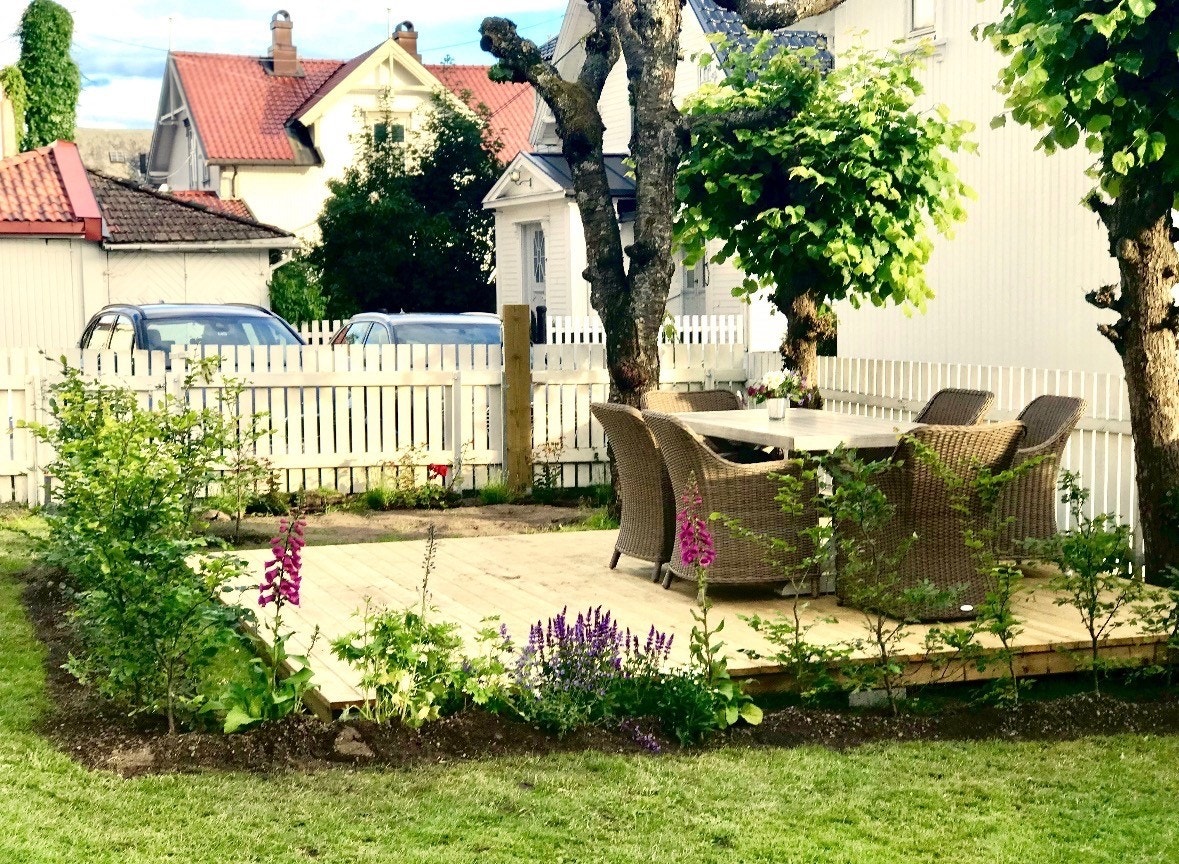 Seksjonert uteområde oppgradert med platting og beplantet med blant annent bøkehekk og roser busker. Galleribilde