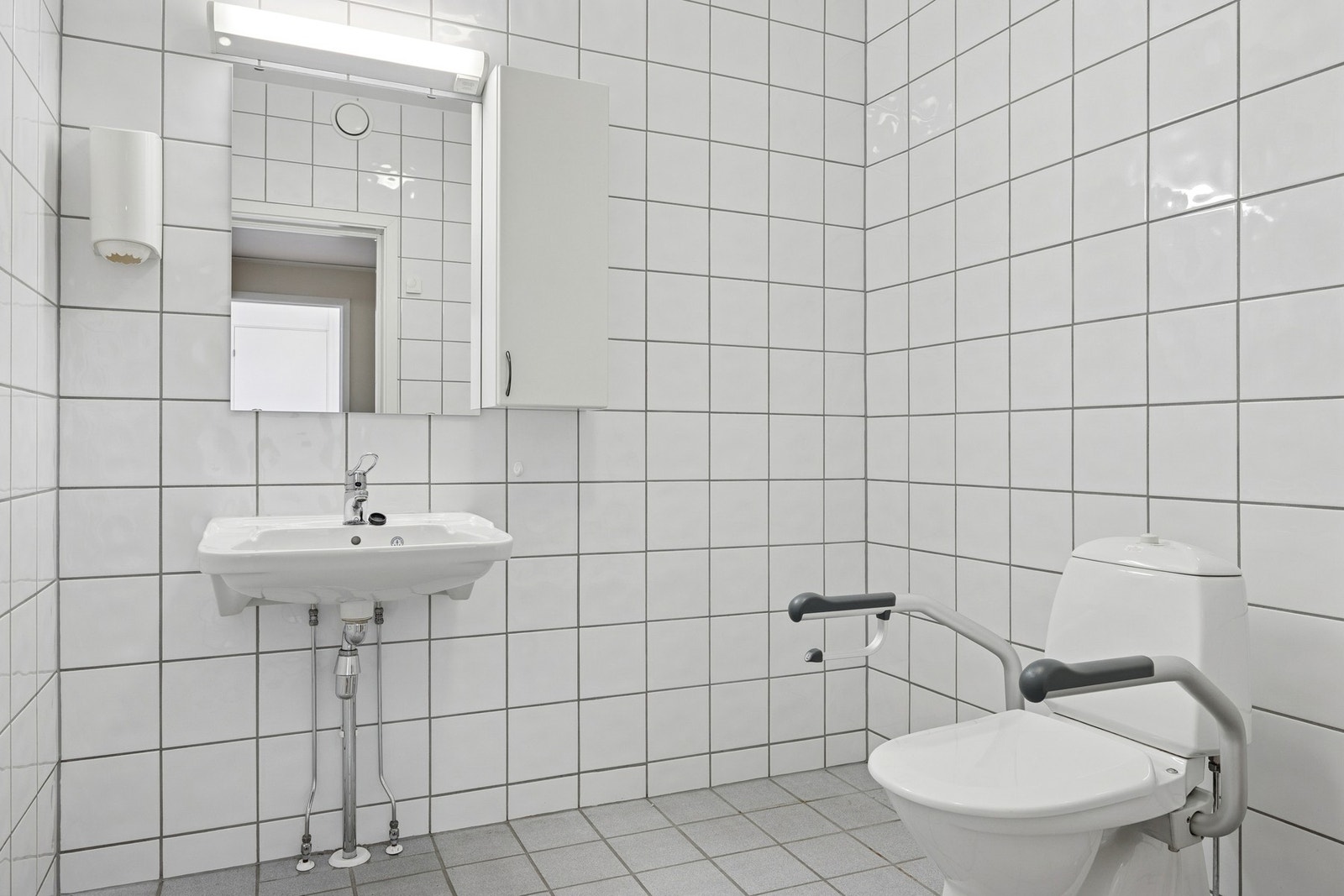 Enkelt vedlikeholdt WC med flislagte overflater. Galleribilde