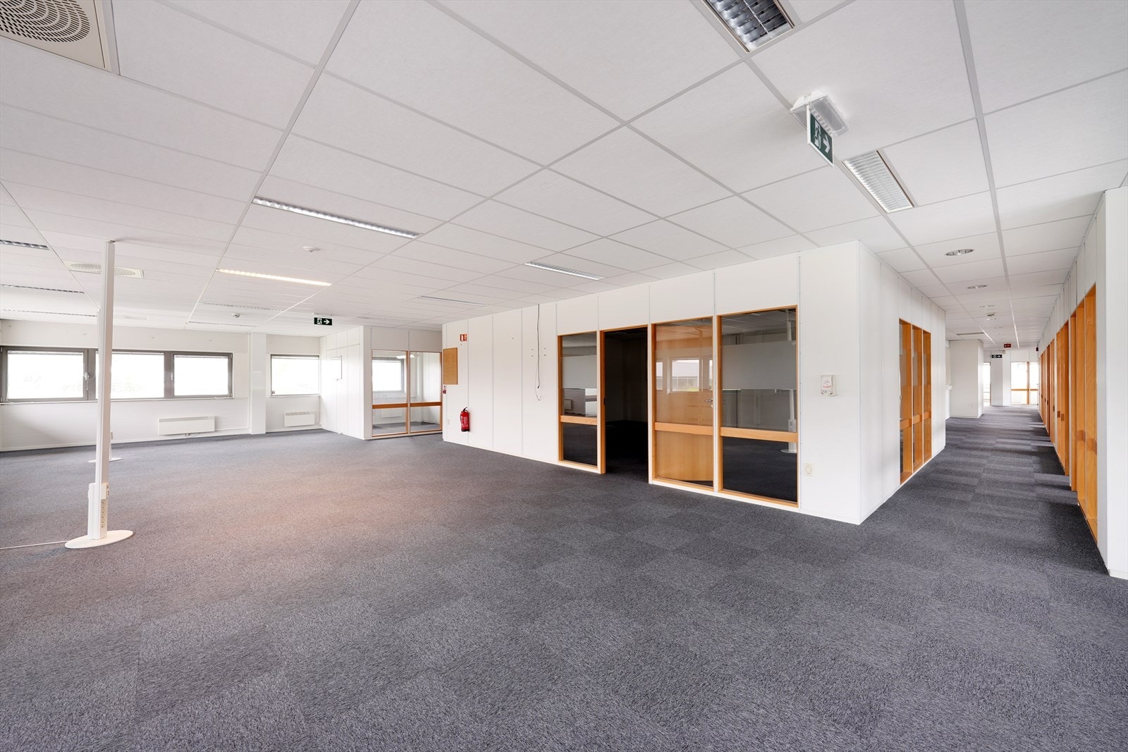 Lys og romslig kontorlokale med store vinduer, godt med naturlig lys, og praktiske romløsninger for et produktivt arbeidsmiljø. Galleribilde