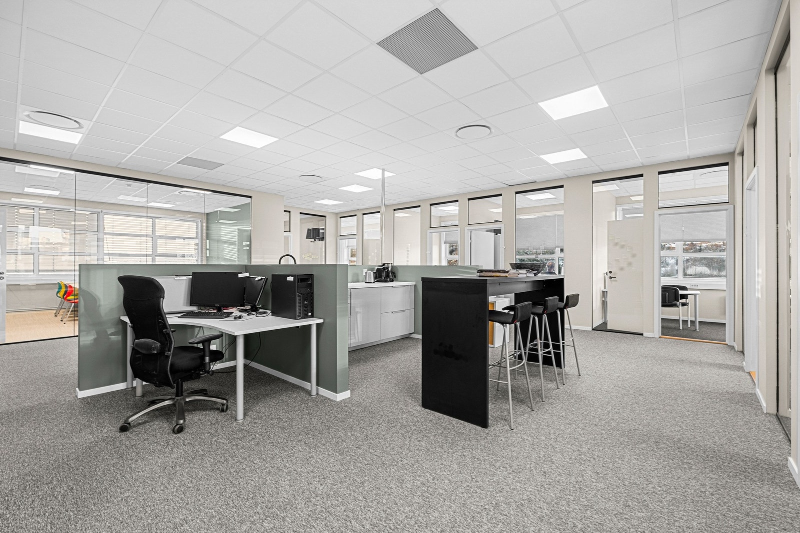 Effektiv planløsning med arbeidsplasser i åpent landskap og cellekontorer langs vindusrekken. Galleribilde