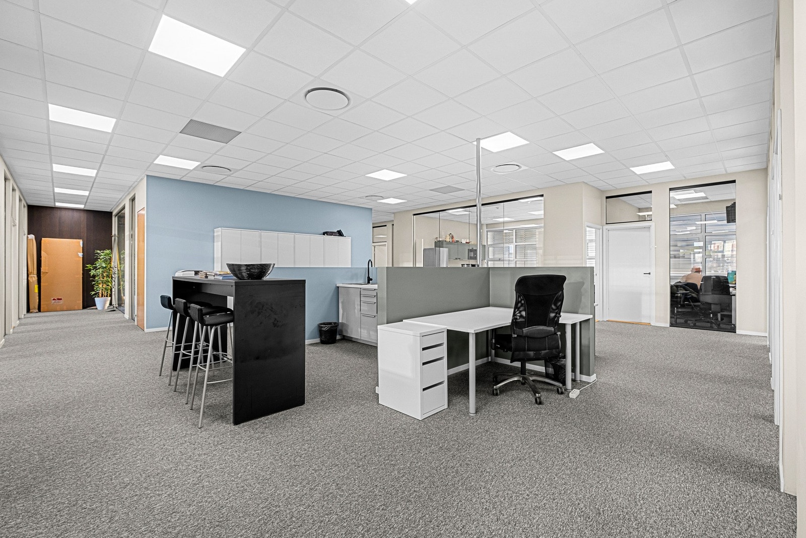 Effektiv planløsning med arbeidsplasser i åpent landskap og cellekontorer langs vindusrekken. Galleribilde