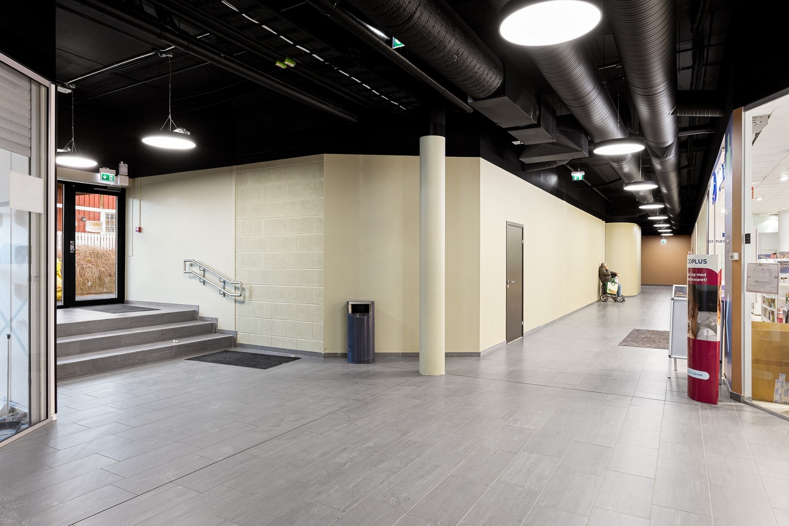 Sideinngang utenfra til fellesarealer, felles kundetoalett (grå dør) samt inngang til Boots apotek. Galleribilde