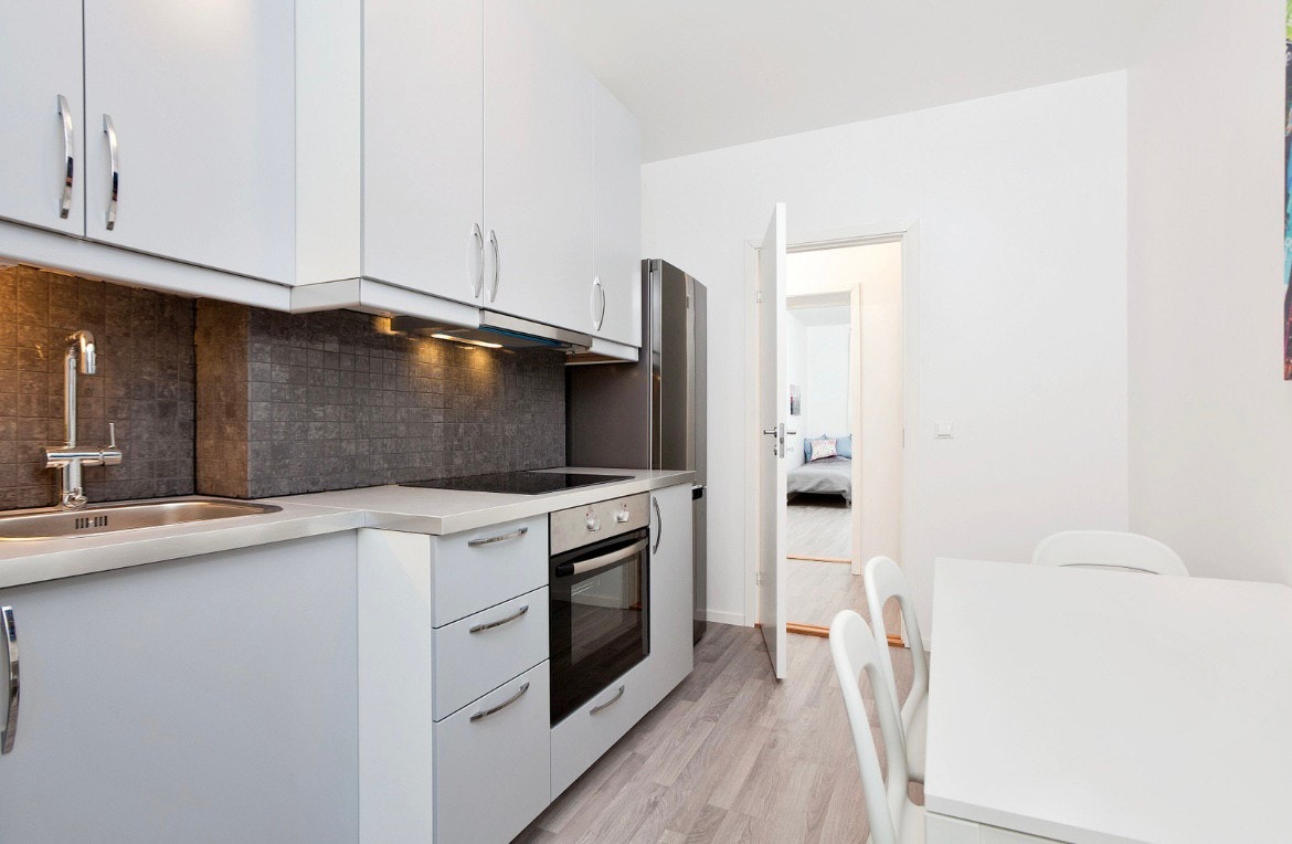 Fult utstyr kjøkken med ovn, platetopp, kjøleskap og mikrobølgeovn. Galleribilde