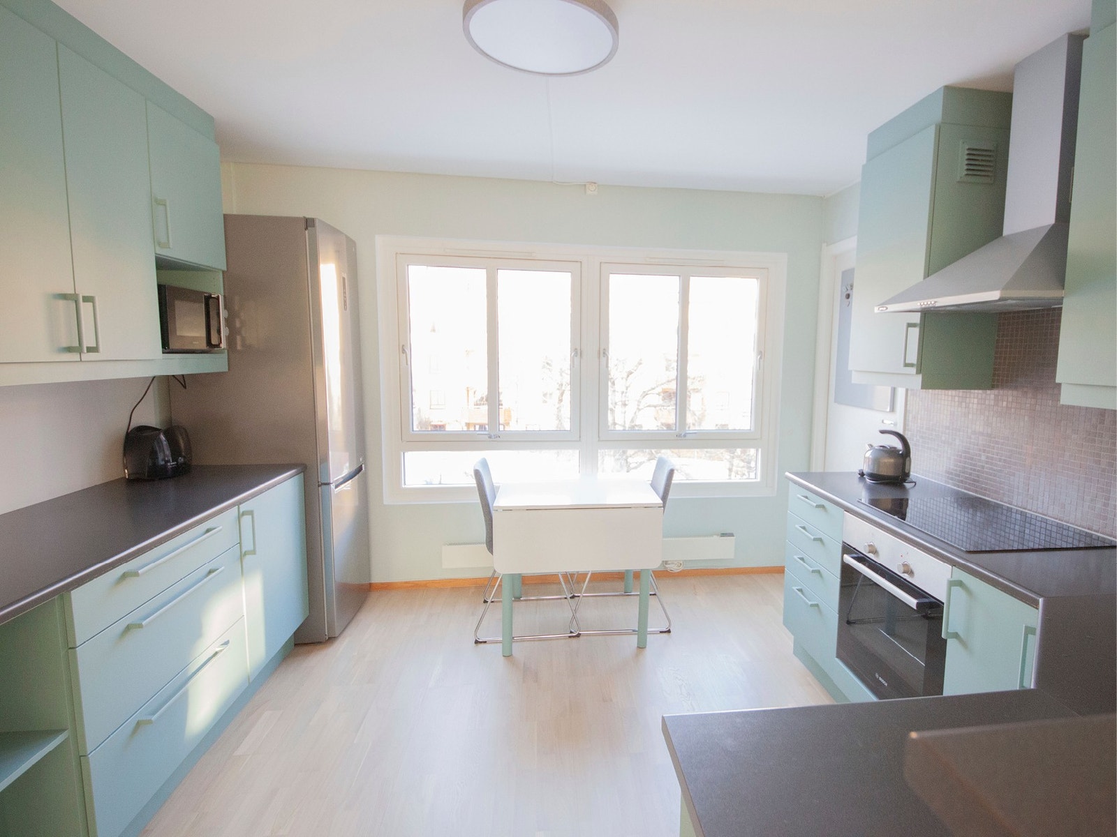 Praktisk kjøkken med frokostplass - utsikt til koselig bakgård og Bjølsenparken. Galleribilde