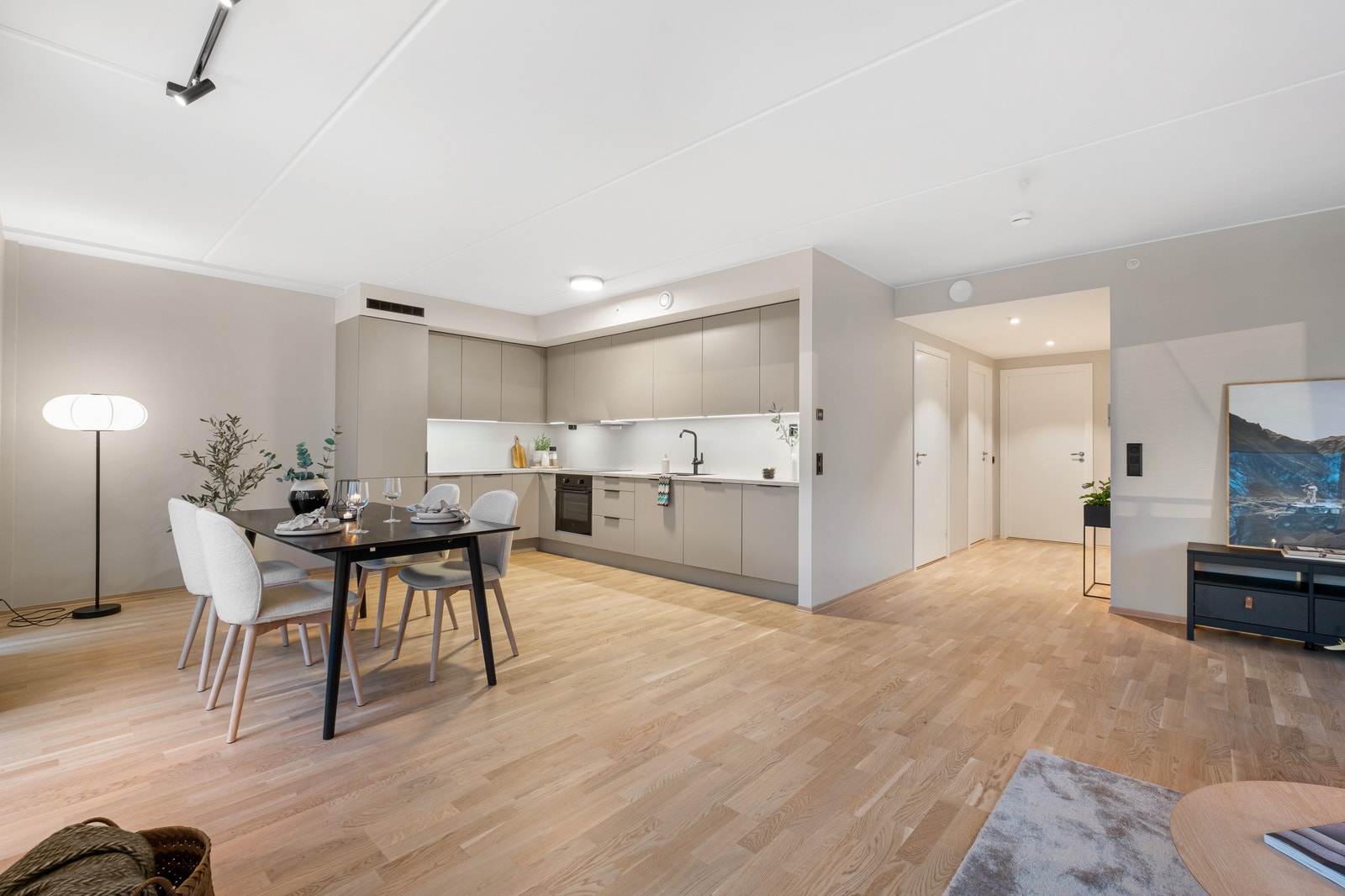 Moderne HTH-kjøkken i en åpen løsning mot stuen, som gjør det enkelt å kombinere matlaging og sosialt samvær. Galleribilde