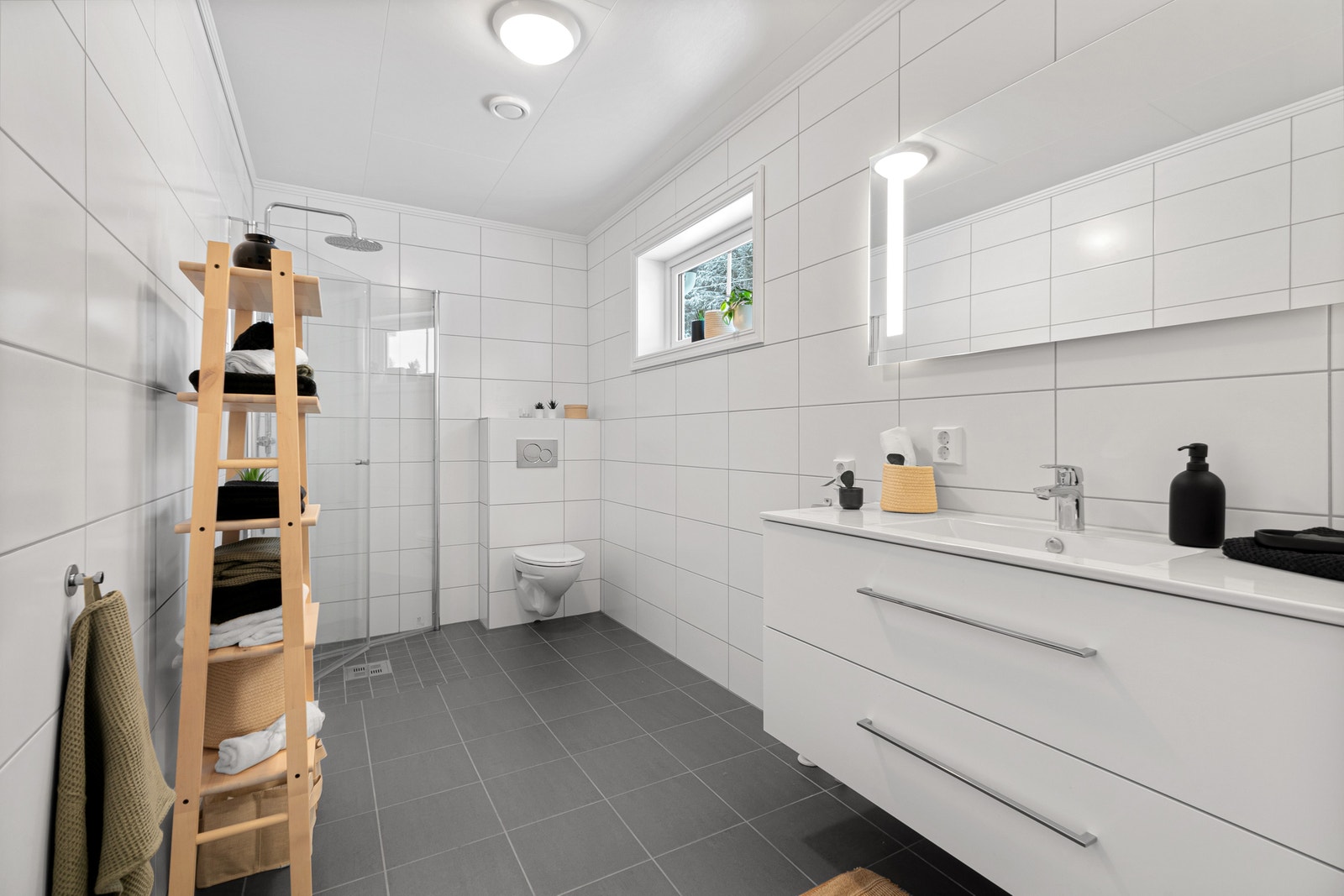 Lyst bad med mørke fliser gulv (Minos Vulcanic) 30x30 med 10x10 cm i dusjsonen. Galleribilde