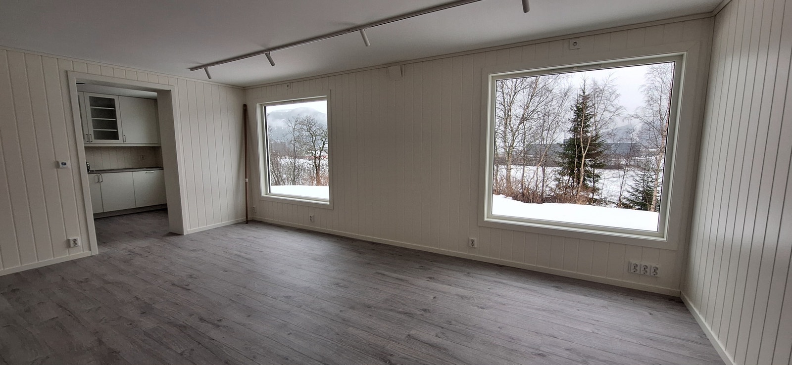 Stue, stor vinduer med utsikt mot veien Galleribilde