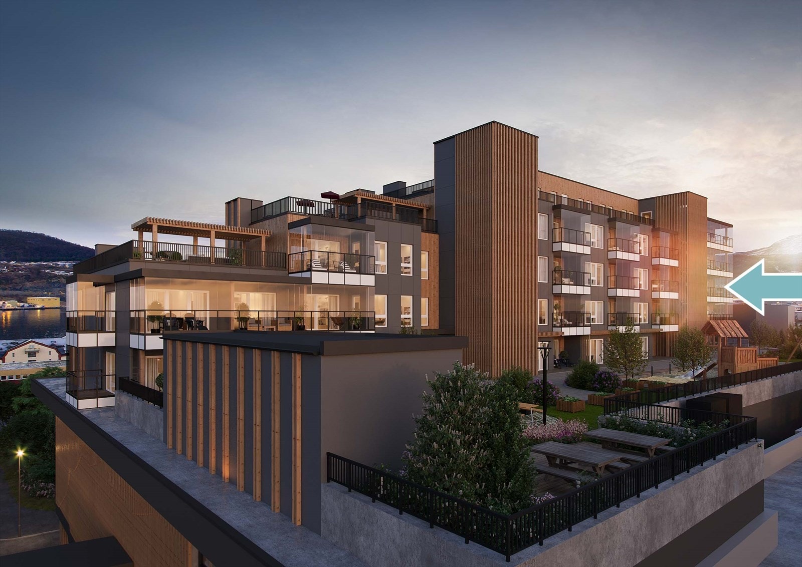 Skjermet mot vest ligger fellesarealet med adkomst, sykkelparkering, lekestativer, benker, beplantning og ly for nordavinden Galleribilde