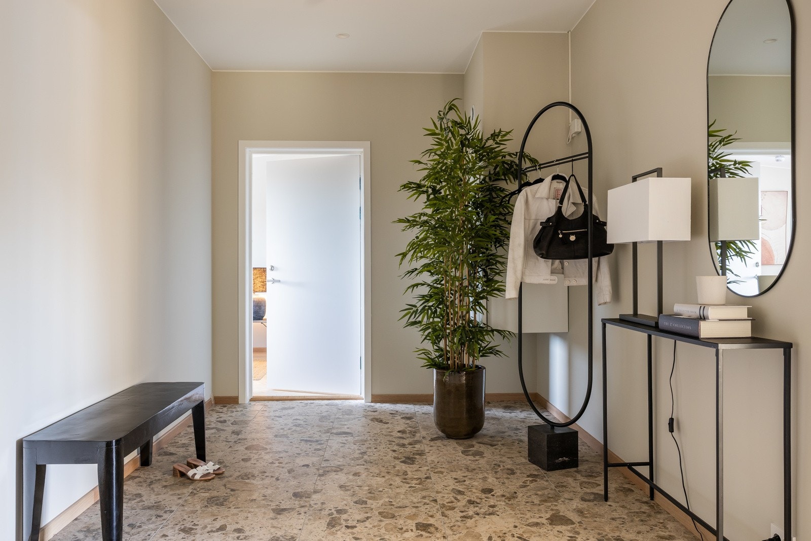 Romslig entre med plass for garderobe. Fliser på gulv. Foto er fra leilighet 3004 som har lik standard og planløsning. Galleribilde