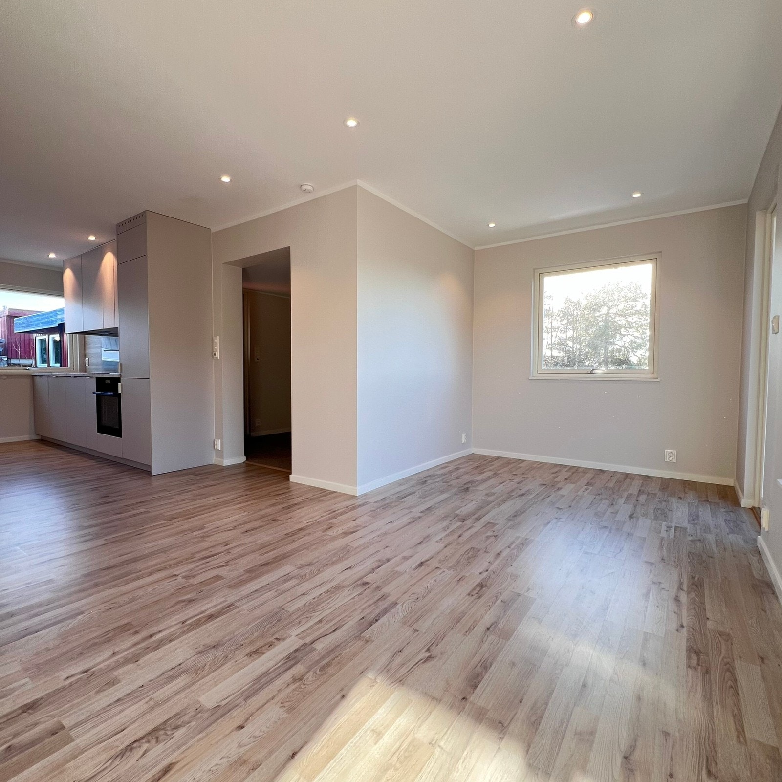 Åpen kjøkken- og stueløsning med sofaområde samt spiseplass Galleribilde