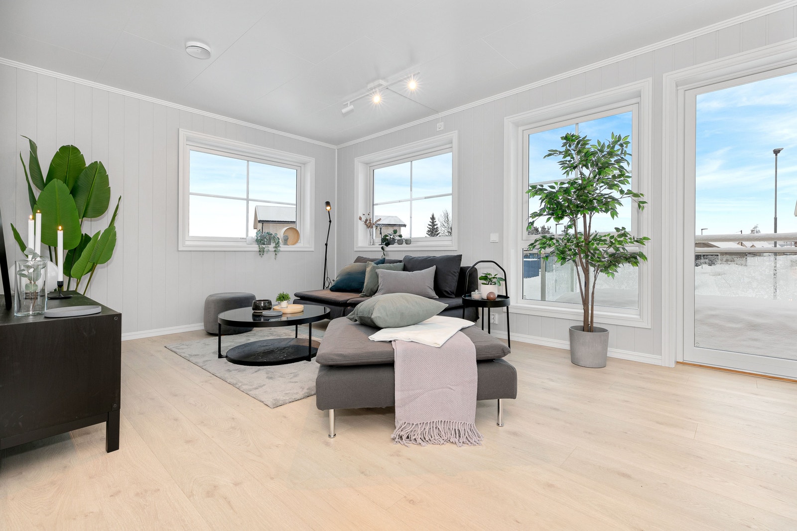 Romslig stue med store vindusflater. Foto er fra annen leilighet med lik planløsning. Galleribilde