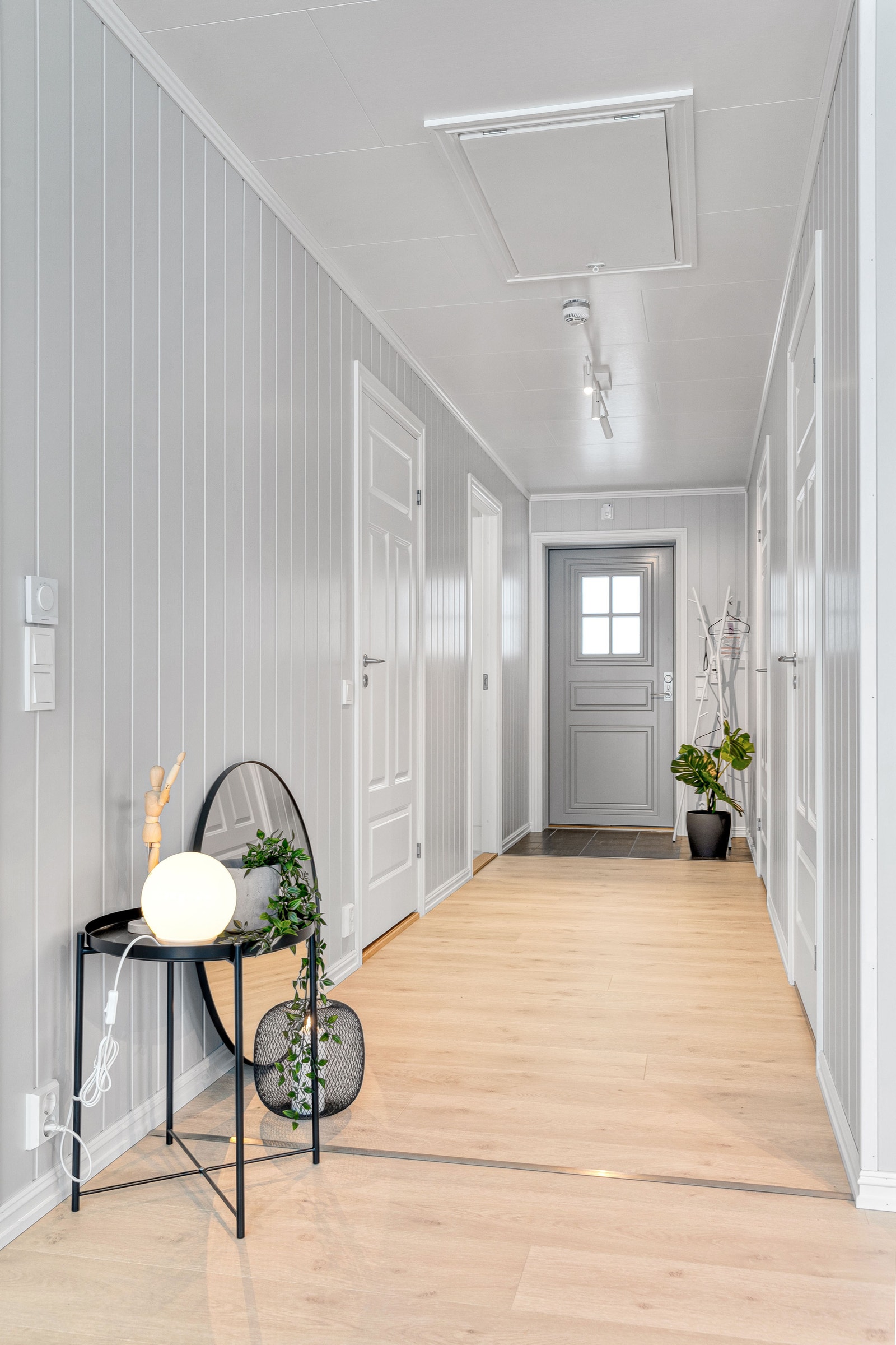 Gang med flislagt område foran inngangsdøren. Fra gangen er det dører inn til soverommene og badet. Foto er fra annen leilighet med lik planløsning. Galleribilde