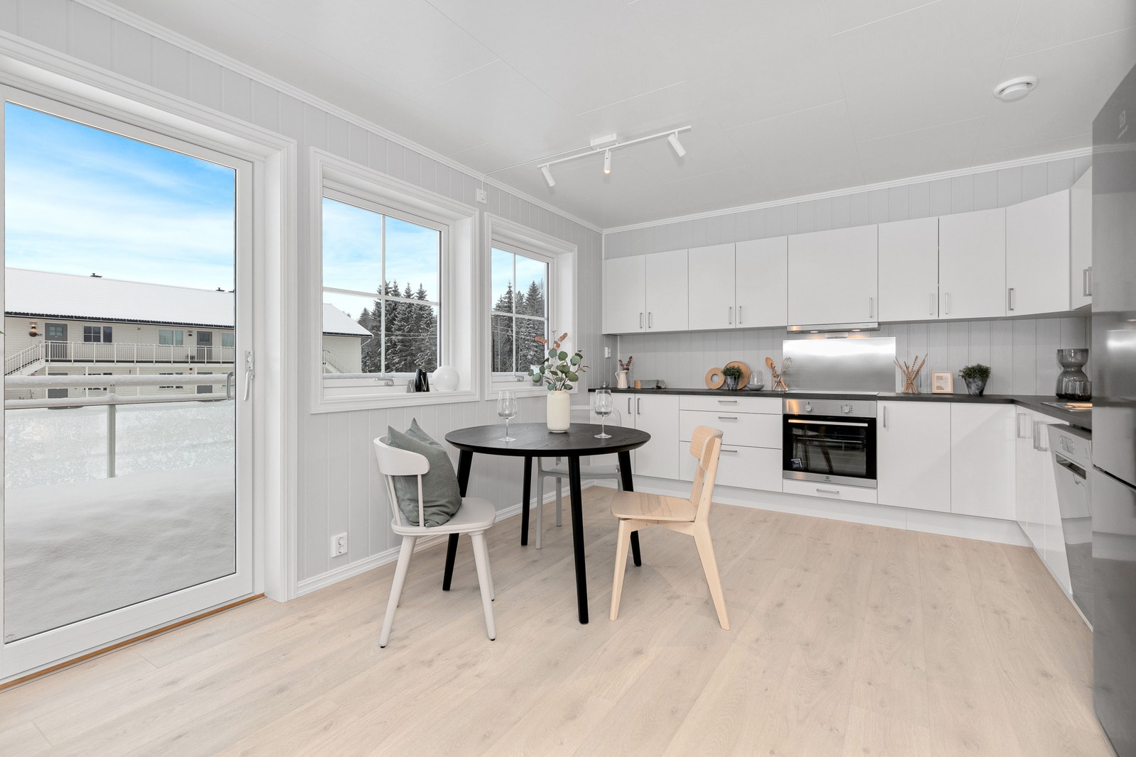 Kjøkken med plass til spisebord ved vinduene. Foto er fra annen leilighet med lik planløsning. Galleribilde