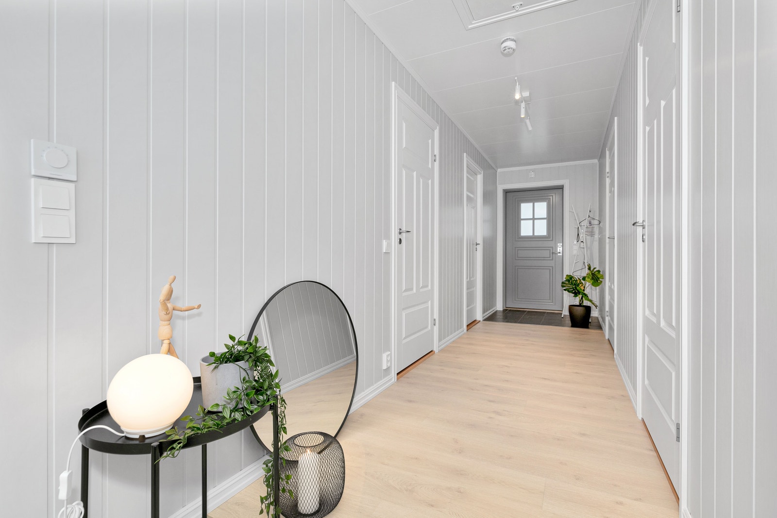 Gang med flislagt område foran inngangsdøren. Fra gangen er det dører inn til soverommene og badet. Foto er fra annen leilighet med lik planløsning. Galleribilde