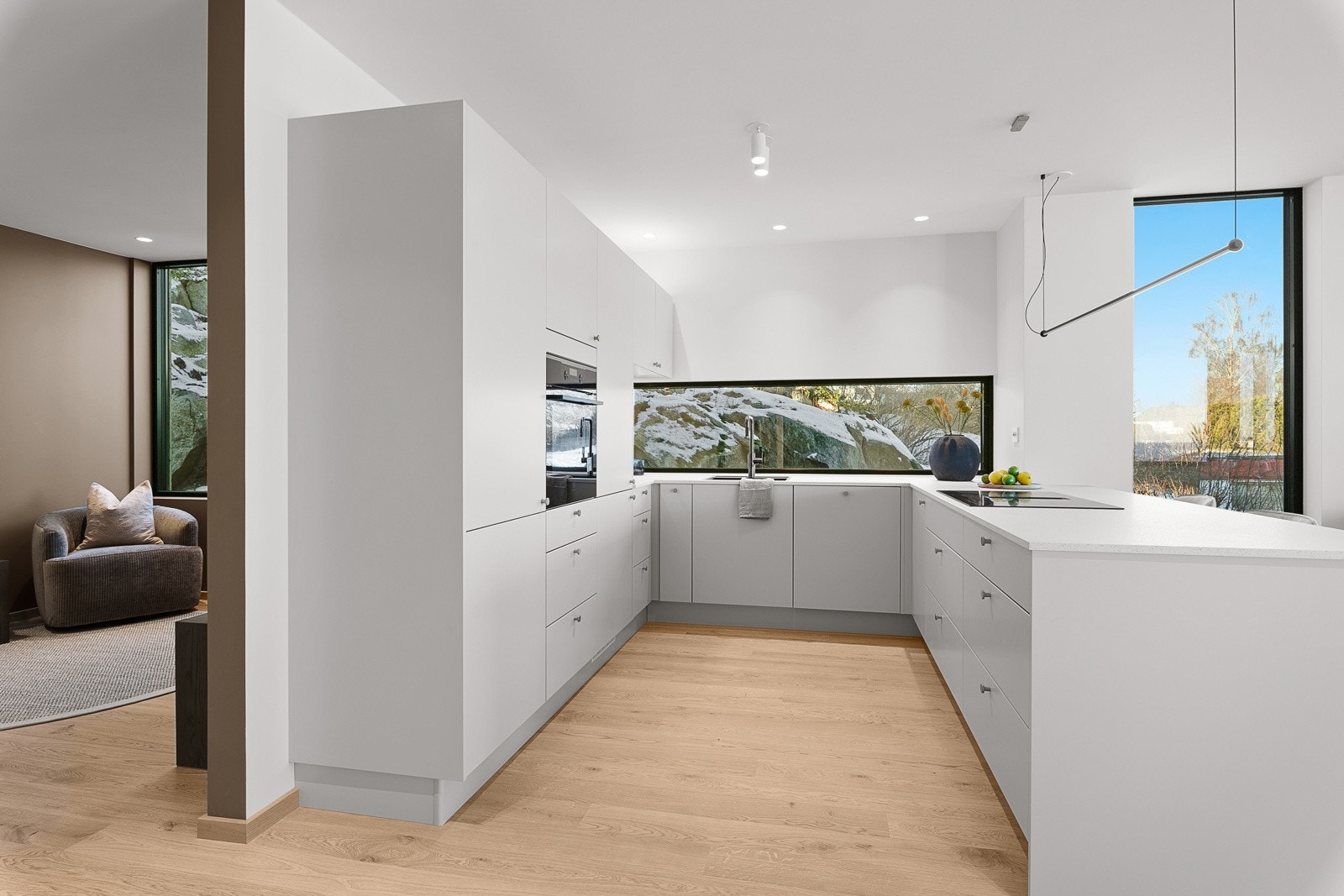 Stilrent kjøkken fra Strai med hvitevarepakke som inneholder oppvaskmaskin, kjøl/fryseskap, stekovn og platetopp med integrert ventilator Galleribilde