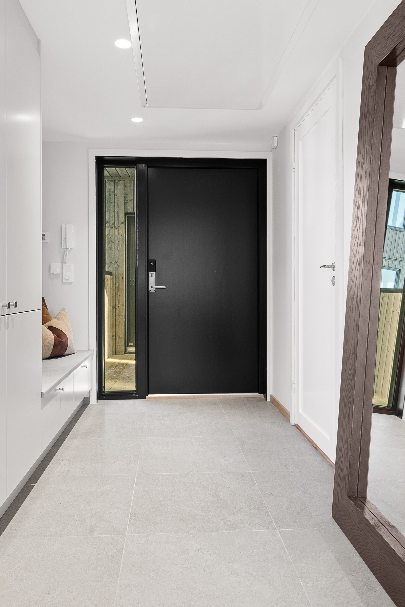 Gangen har garderobeskap og praktisk sittebenk Galleribilde